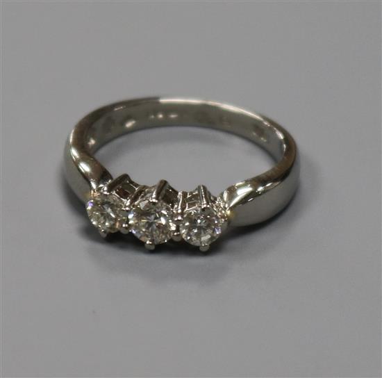 A modern platinum and three stone diamond ring, size J.